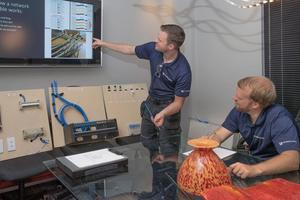 Jonathan Running training one of his technicians how to install a network cable